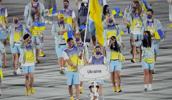 Olena Kostevych and Bogdan Nikishin, of Ukraine, carry their country&#39;s flag during the opening ceremony in the Olympic Stadium at the 2020 Summer Olympics, on July 23, 2021, in Tokyo, Japan. Ukraine has stepped up efforts to lobby international sports leaders against Russian participation in next year’s Paris Olympics as indications mount that the games could see the biggest boycott since the Cold War. (AP Photo/David J. Phillip, File)