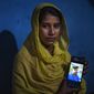 Sonali Begum, 17, displays a photo of her husband Siddique Ali, 23, who was picked up by the police, at her rented house in Guwahati, India, Saturday, Feb. 4, 2023. Indian police have arrested more than 2,000 men in a crackdown on illegal child marriages in involving girls under the age of 18 a northeastern state. Begum is seven months pregnant. (AP Photo/Anupam Nath)