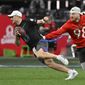 AFC defensive end Maxx Crosby (98) of the Las Vegas Raiders reaches for the flag of NFC quarterback Kirk Cousins (8) of the Minnesota Vikings during the flag football event at the NFL Pro Bowl, Sunday, Feb. 5, 2023, in Las Vegas. (AP Photo/David Becker)
