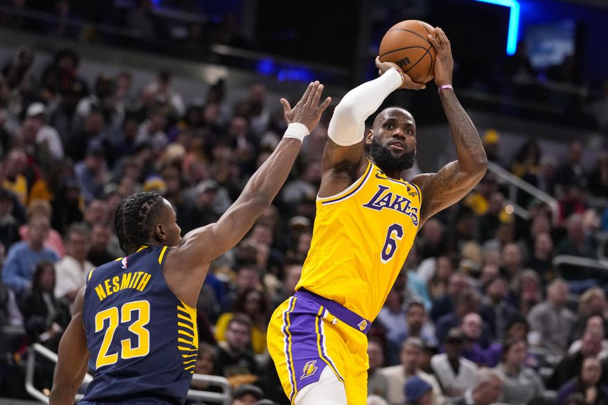 FILE - Los Angeles Lakers forward LeBron James (6) shoots over Indiana Pacers forward Aaron Nesmith (23) during the first half of an NBA basketball game in Indianapolis, Thursday, Feb. 2, 2023. Lakers coach Darvin Ham, in an essay for The Associated Press, says James&#x27; work ethic is beyond compare. James is about to pass Kareem Abdul-Jabbar for the NBA career scoring record. (AP Photo/Michael Conroy, File)
