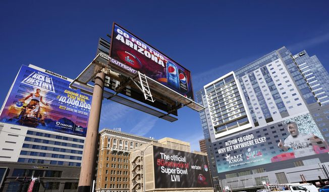 Large advertisements adorn buildings and electronic billboards leading up to the NFL Super Bowl LVII football game in Phoenix, Friday, Feb. 3, 2023. (AP Photo/Ross D. Franklin)