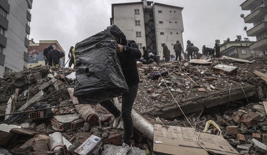 People and emergency teams search for people in the rubble in a destroyed building in Gaziantep, Turkey, Monday, Feb. 6, 2023. A powerful quake has knocked down multiple buildings in southeast Turkey and Syria and many casualties are feared. (AP Photo/Mustafa Karali)