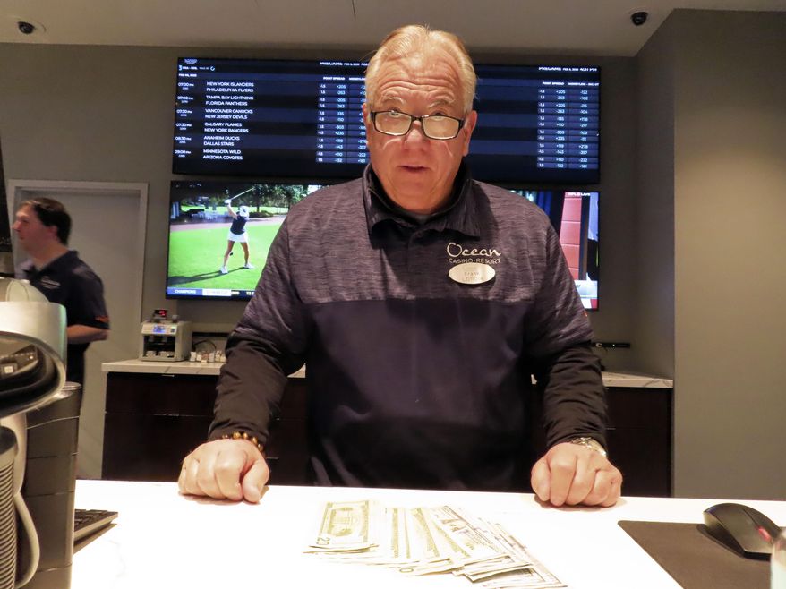 Frank Caltagirone, a sports book employee at the Ocean Casino Resort in Atlantic City, N.J., counts money from his drawer Monday, Feb. 6, 2023. On Feb. 7, 2023, the gambling industry&#x27;s national trade group, the American Gaming Association, predicted that over 50 million American adults will bet a total of $16 billion on this year&#x27;s Super Bowl, including legal bets with sports books, illegal ones with bookies, and casual bets among friends or relatives. (AP Photo/Wayne Parry)