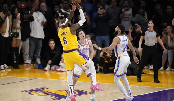 Los Angeles Lakers forward LeBron James, left, scores to pass Kareem Abdul-Jabbar to become the NBA&#x27;s all-time leading scorer as Oklahoma City Thunder guard Josh Giddey, center, and forward Kenrich Williams defend during the second half of an NBA basketball game Tuesday, Feb. 7, 2023, in Los Angeles. (AP Photo/Mark J. Terrill)