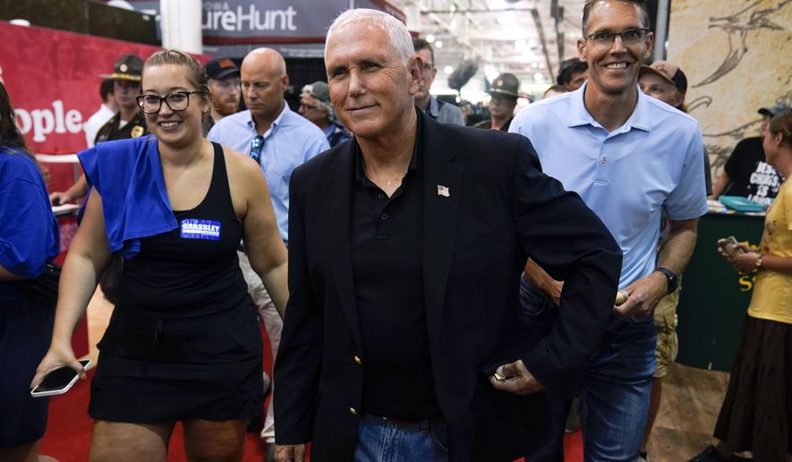 Former Vice President Mike Pence walks through the Varied Industries Building during a visit to the Iowa State Fair, Friday, Aug. 19, 2022, in Des Moines, Iowa. Pence is stepping up his outreach in Iowa ahead of a possible 2024 presidential campaign. (AP Photo/Charlie Neibergall, File)