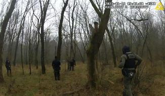 In this image taken from body cam video released by the Atlanta Police Department, officers respond to gunfire in the distance near the future site of City of Atlanta’s Public Safety Training Center on Jan. 18, 2023, near Atlanta, Ga. Authorities said Manuel Esteban Paez Teran, an environmental activist who went by the name Tortuguita, died at the scene, and a state trooper was injured with a gunshot wound. (Atlanta Police Department via AP)