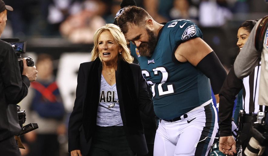 First lady Jill Biden talks with Philadelphia Eagles center Jason Kelce (62) before the coin toss before an NFL football game against the Dallas Cowboys, Oct. 16, 2022, in Philadelphia. (AP Photo/Rich Schultz, File)