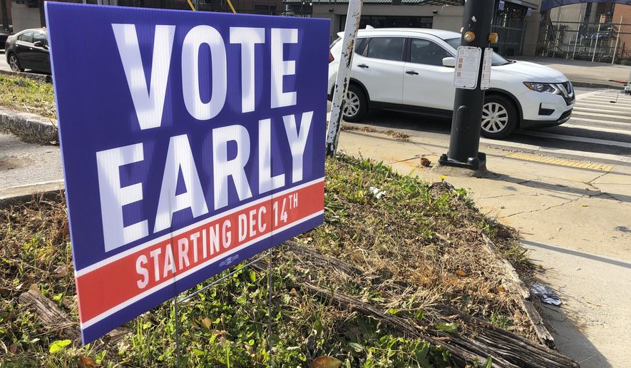 In this Dec. 11, 2020 file photo, a sign in an Atlanta neighborhood  urges people to vote early in Georgia&#x27;s two U.S. Senate races. (AP Photo/Jeff Amy, File)