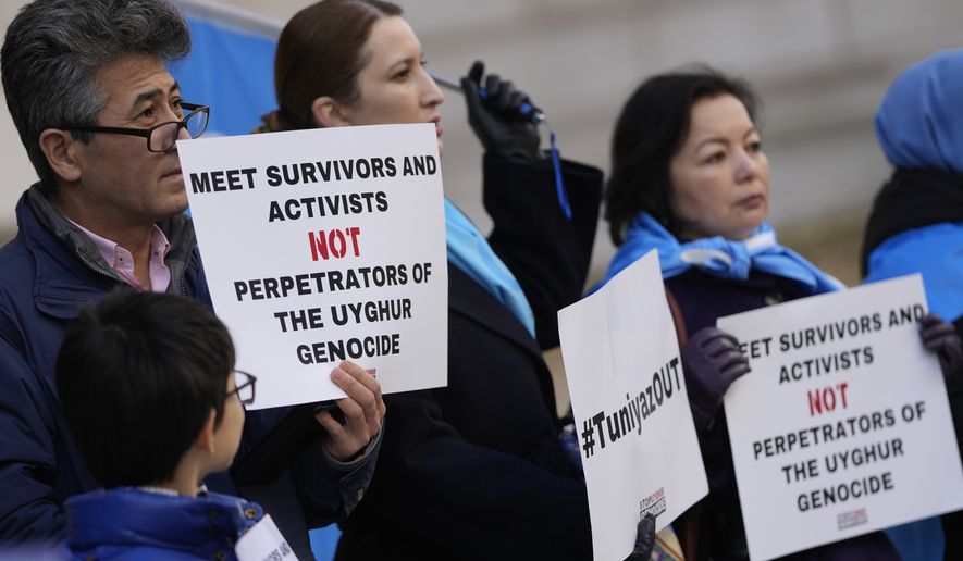 Activists and community members hold a small protest outside the British Foreign Office in central London, Monday, Feb. 13, 2023. The protesters are demanding a meeting with Foreign Secretary James Cleverly to highlight their concerns for their compatriots in the Chinese Xinjiang Uyghur Autonomous Region. (AP Photo/Alastair Grant)