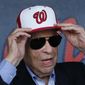 In this Feb. 28, 2017, file photo, Washington Nationals owner Ted Lerner tries on a baseball cap before a ribbon cutting ceremony to open The Ballpark in West Palm Beach, Fla. Washington Nationals founder Ted Lerner has died. He was 97. Lerner bought the team from Major League Baseball in 2006 for $450 million. He was managing principal owner until ceding that role to son Mark in 2018. (AP Photo/John Bazemore, File) **FILE**