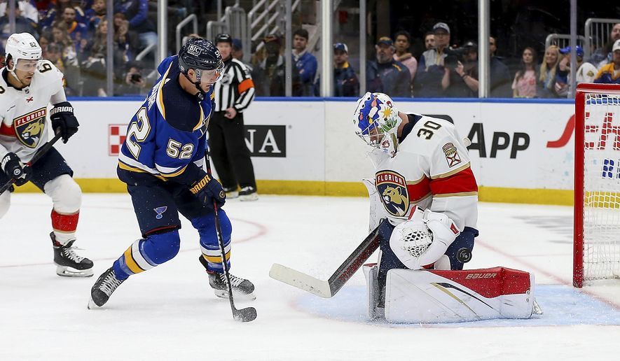 Florida Panthers goaltender Spencer Knight (30) deflects a shot on goal from St. Louis Blues&#x27; Noel Acciari (52) during the second period of an NHL hockey game, Tuesday, Feb. 14, 2023, in St. Louis. (AP Photo/Scott Kane)