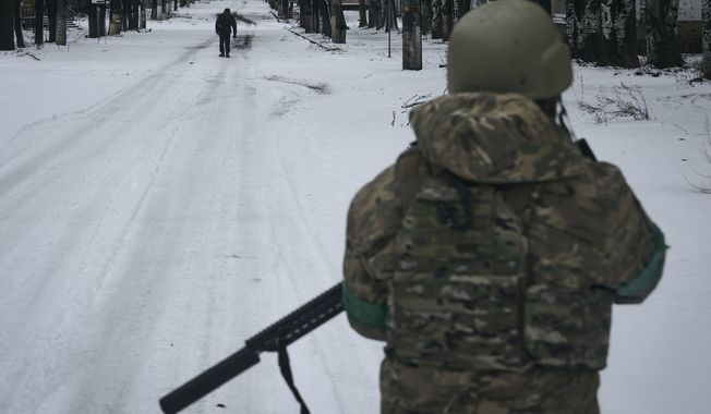 A Ukrainian soldier patrols the street in Bakhmut, Donetsk region, Ukraine, Tuesday, Feb. 14, 2023. (AP Photo/Libkos)