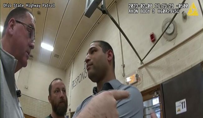 This photo provided by Ohio State Highway Patrol shows police bodycam footage of NewsNation correspondent Evan Lambert interaction with authorities Wednesday, Feb. 8, 2023 in the gymnasium of an elementary school in East Palestine, Ohio. Lambert was charged with criminal trespass and resisting arrest after authorities said he was told to stop his live broadcast and then refused their orders to leave the news conference with Ohio Gov. Mike DeWine. (Ohio State Highway Patrol via AP)