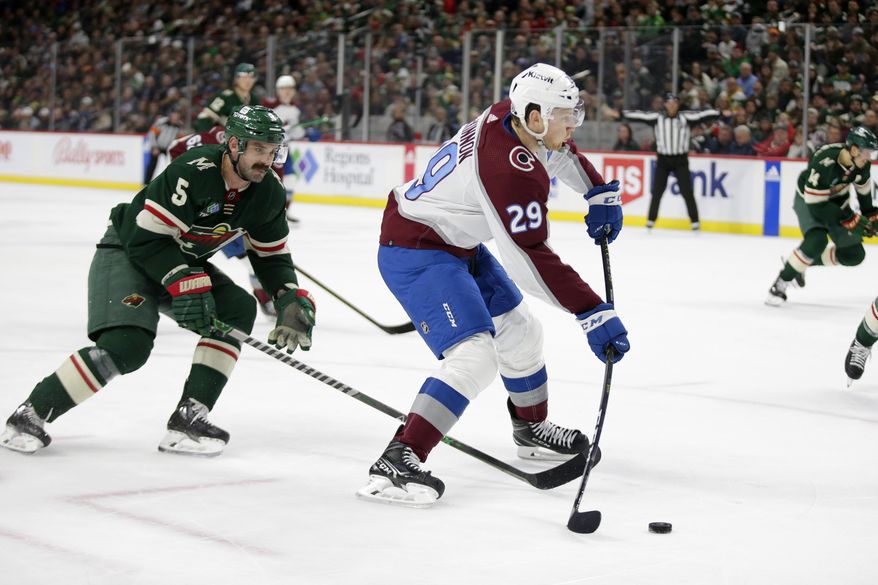 Colorado Avalanche center Nathan MacKinnon (29) shoots a goal with Minnesota Wild defenseman Jake Middleton (5) looking on in the second period of an NHL hockey game Wednesday, Feb. 15, 2023, in St. Paul, Minn. (AP Photo/Andy Clayton-King)