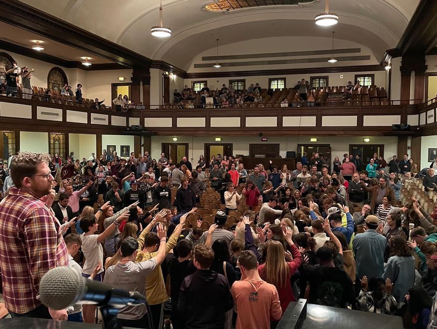 Students and others at Asbury University pray with arms extended during a continuous worship meeting that began Feb. 8 and is ongoing at the Christian school in Wilmore, Kentucky. The town of 6,000 has had its population swell with visitors seeking a spiritual experience there. (Photo by Josh Sadlon/Focus on the Family; used with permission.)