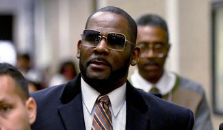 R. Kelly, center, leaves the Daley Center after a hearing in his child support case on May 8, 2019, in Chicago. Federal prosecutors asked a judge Thursday, Feb. 16, 2023, to give singer R. Kelly 25 more years in prison for his child pornography and enticement convictions last year in Chicago, which would add to 30 years he recently began serving in a New York case. (AP Photo/Matt Marton, File)