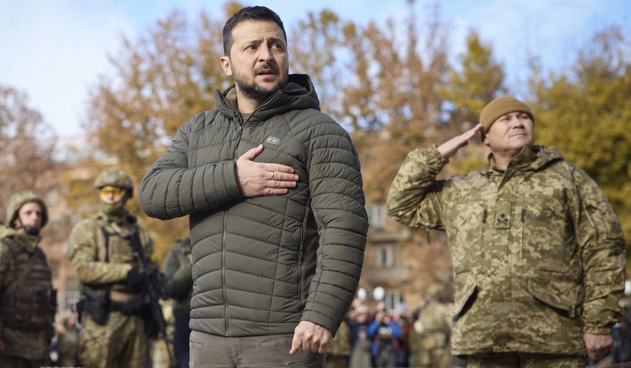 In this photo provided by the Ukrainian Presidential Press Office, Ukrainian President Volodymyr Zelenskyy listens to the national anthem during his visit to Kherson, Ukraine, Monday, Nov. 14, 2022. Ukraine&#x27;s retaking of Kherson was a significant setback for the Kremlin and it came some six weeks after Russian President Vladimir Putin annexed the Kherson region and three other provinces in southern and eastern Ukraine — in breach of international law — and declared them Russian territory. (Ukrainian Presidential Press Office via AP, File)