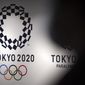 A person walks near Tokyo 2020 logo in Haneda Airport on June 14, 2021, in Tokyo. A trial looking into widespread bribery at the Tokyo Olympic organizing committee began Friday, Feb. 17, 2023, with a former head of a major ad company admitting to the charges. (AP Photo/Eugene Hoshiko, File)