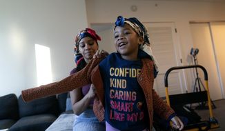 Johnae Strong helps her 6-year-old daughter Jari Akim with her coat as they ready for school and work Friday, Feb. 10, 2023, in Chicago. (AP Photo/Erin Hooley) **FILE**