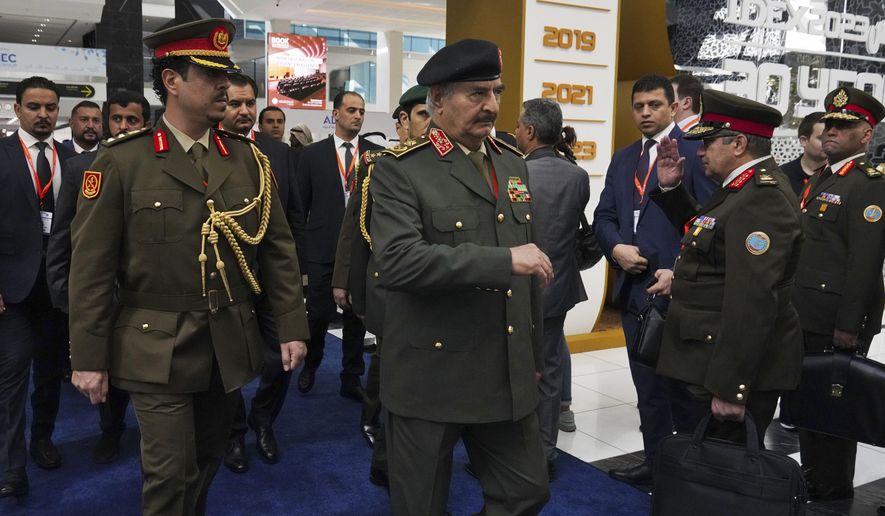 Libya&#x27;s Khalifa Hifter, the commander of the self-styled Libyan National Army, center, is seen at the International Defense Exhibition and Conference in Abu Dhabi, United Arab Emirates, Monday, Feb. 20, 2023. Just outside of Abu Dhabi&#x27;s biennial arms fair in a large tent, Russia offered weapons for sale Monday ranging from Kalashnikov assault rifles to missile systems despite facing sanctions from the West over its war on Ukraine. (AP Photo/Jon Gambrell)
