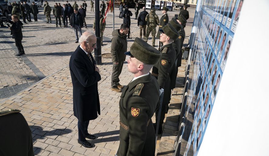 President Joe Biden, left, participates in a wreath-laying ceremony with Ukrainian President Volodymyr Zelenskyy at the memorial wall outside of St. Michael&#x27;s Golden-Domed Cathedral during an unannounced visit, in Kyiv, Ukraine, Monday, Feb. 20, 2023. (AP Photo/Evan Vucci)