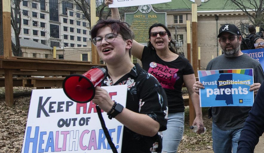 Leviathan Myers-Rowell, 16, from left, of Ocean Springs, Miss., and his parents Jodi and Thomas Rowell march from the state Capitol toward the governor&#x27;s mansion following a rally at the Capitol in support of transgender youth and in opposition to House Bill 1125 in Jackson, Miss., Wednesday, Feb. 15, 2022. HB 1125 prohibits transgender-related healthcare in Mississippi for people under the age of 18. (Barbara Gauntt//The Clarion-Ledger via AP)
