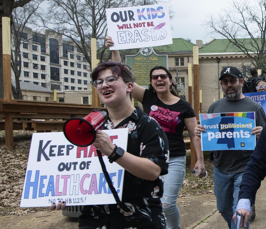 Leviathan Myers-Rowell, 16, from left, of Ocean Springs, Miss., and his parents Jodi and Thomas Rowell march from the state Capitol toward the governor&#x27;s mansion following a rally at the Capitol in support of transgender youth and in opposition to House Bill 1125 in Jackson, Miss., Wednesday, Feb. 15, 2022. HB 1125 prohibits transgender-related healthcare in Mississippi for people under the age of 18. (Barbara Gauntt//The Clarion-Ledger via AP)