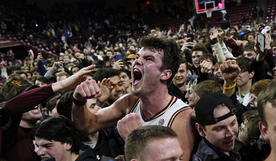 Boston College forward Quinten Post celebrates with fans after upsetting Virginia 63-48 after an NCAA college basketball game, Wednesday, Feb. 22, 2023, in Boston. (AP Photo/Charles Krupa)