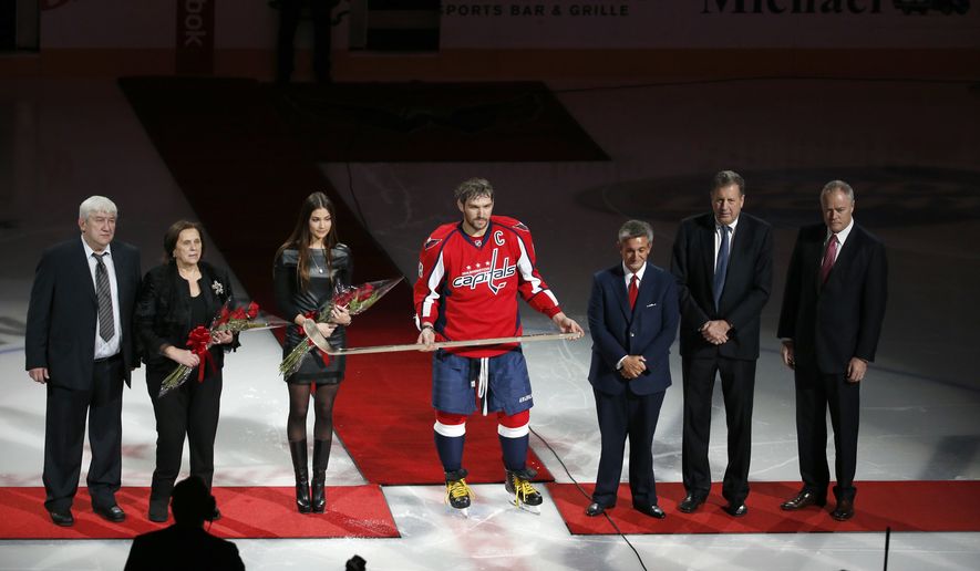 FILE - Mikhail Ovechkin, left, Tatyana Ovechkin, and fiancee Nastya Shubskay stand with Washington Capitals left wing Alex Ovechkin after he was presented a commemorative hockey stick by owner Ted Leonsis, president Dick Patrick, and general manager Brian MacLellan before an NHL hockey game against the Vancouver Canucks, Thursday, Jan. 14, 2016, in Washington. Ovechkin returned to the Washington Capitals on Wednesday after missing four games over the past week after the death of his father in Moscow. (AP Photo/Alex Brandon)
