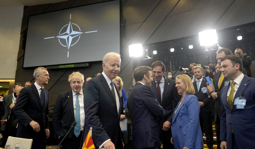 U.S. President Joe Biden, center, arrives for a round table meeting during an extraordinary NATO summit at NATO headquarters in Brussels, Thursday, March 24, 2022. War has been a catastrophe for Ukraine and a crisis for the globe. One year on, thousands of civilians are dead, and countless buildings have been destroyed. Hundreds of thousands of troops have been killed or wounded on each side. Beyond Ukraine’s borders, the invasion shattered European security, redrew nations’ relations with one another and frayed a tightly woven global economy. (AP Photo/Markus Schreiber, File)