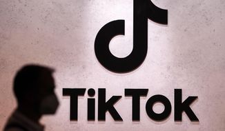 A visitor passes the TikTok exhibition stands at the Gamescom computer gaming fair in Cologne, Germany, Thursday, Aug. 25, 2022. The European Union&#x27;s executive arm said Thursday, Feb. 23, 2023 it has temporarily banned TikTok from phones used by employees as a cybersecurity measure, reflecting growing worries from authorities over the Chinese-owned video sharing app. (AP Photo/Martin Meissner) **FILE**