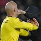 A PSV supporter punches Sevilla&#x27;s goalkeeper Marko Dmitrovic in the face during the Europa League playoff second leg soccer match between PSV and Sevilla at the Philips stadium in Eindhoven, Netherlands, Thursday, Feb. 23, 2023. Sevilla won 3-2 on aggregate. (AP Photo/Peter Dejong)
