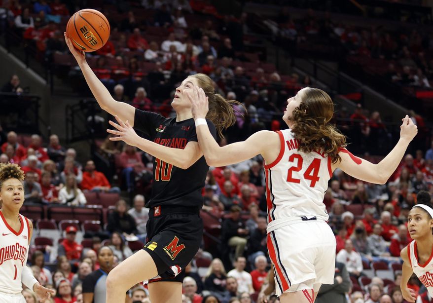 Maryland guard Abby Meyers, left, shoots in front of Ohio State guard Taylor Mikesell during the first half of an NCAA college basketball game in Columbus, Ohio, Friday, Feb. 24, 2023. (AP Photo/Paul Vernon)
