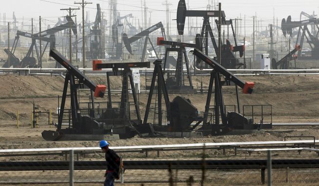 A worker walks near pumpjacks operating at the Kern River Oil Field in Bakersfield, Calif., Jan. 16, 2015. The oil and gas industry’s emissions are a main cause of climate change and in the past the industry undermined sound evidence that carbon greenhouse gases warm the atmosphere. (AP Photo/Jae C. Hong, File)