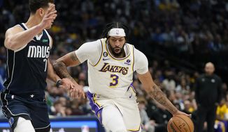 Los Angeles Lakers forward Anthony Davis (3) dribbles against Dallas Mavericks center Dwight Powell (7) during the first half of an NBA basketball game in Dallas, Sunday, Feb. 26, 2023. (AP Photo/LM Otero)