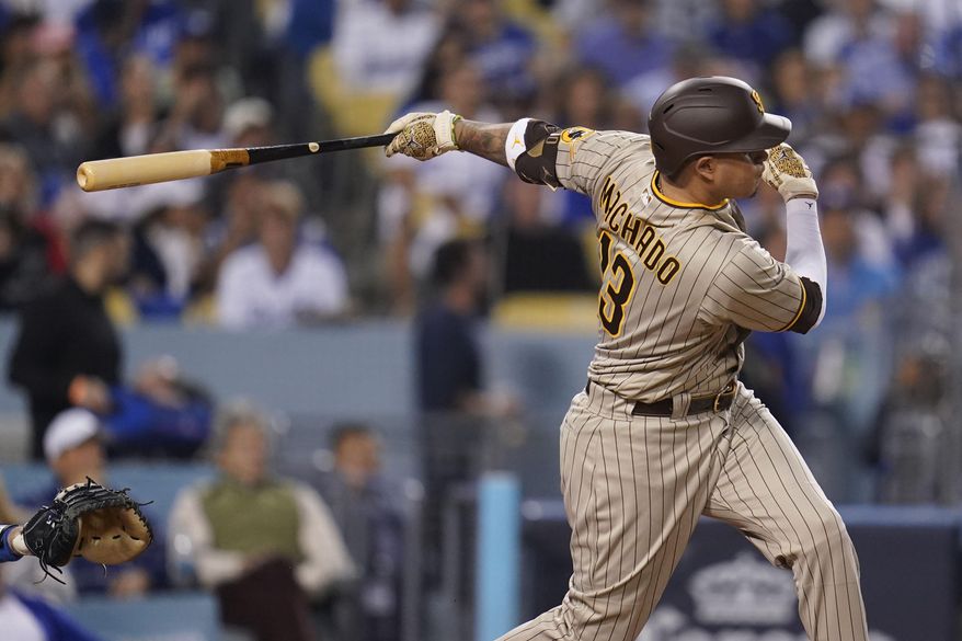 San Diego Padres' Manny Machado follows through on an RBI-double during the third inning in Game 2 of a baseball NL Division Series against the Los Angeles Dodgers, Oct. 12, 2022, in Los Angeles. Machado has agreed to a new $350 million, 11-year contract that will keep him with the San Diego Padres through 2033, according to a person with knowledge of the deal, on Sunday, Feb. 26, 2023. (AP Photo/Ashley Landis, File) **FILE**