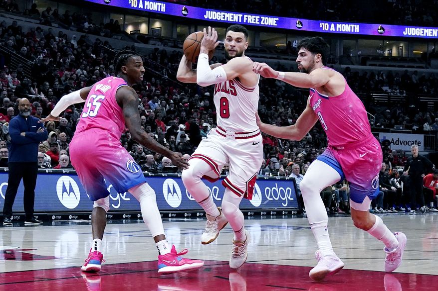 Chicago Bulls guard Zach LaVine, center, drives as Washington Wizards guard Delon Wright, left, and forward Deni Avdija guard during the first half of an NBA basketball game in Chicago, Sunday, Feb. 26, 2023. (AP Photo/Nam Y. Huh)