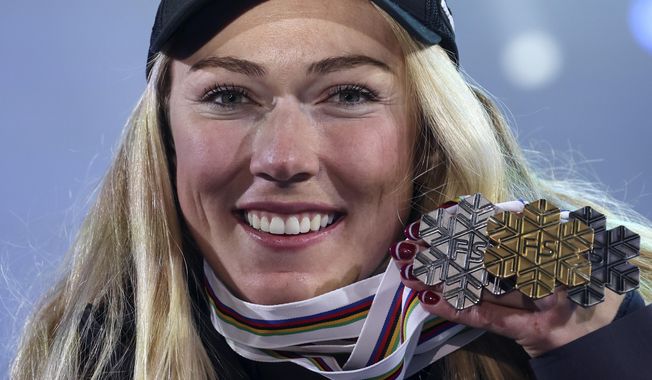 United States&#x27; Mikaela Shiffrin shows her silver medal of the women&#x27;s World Championship slalom, the gold medal of the giant slalom and the silver of the combined, in Meribel, France, Saturday Feb. 18, 2023. (AP Photo/Alessandro Trovati)