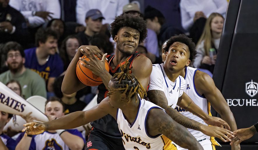 Houston&#x27;s Jarace Walker tries to keep the ball from East Carolina&#x27;s RJ Felton (3) and Brandon Johnson, right, during an NCAA college basketball game in Greenville, N.C., Saturday, Feb. 25, 2023. (AP Photo/Ben McKeown) **FILE**