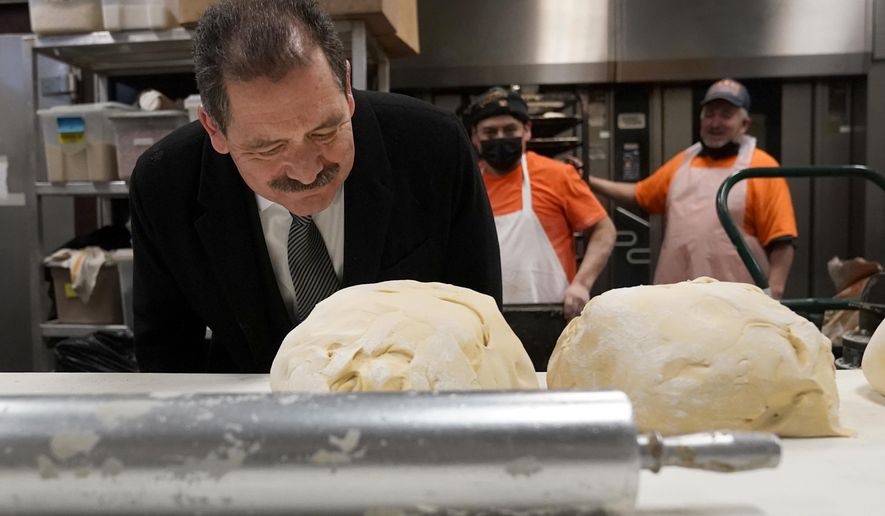 Chicago mayoral candidate Rep., Jesus &quot;Chuy&quot; Garcia, D-Ill., bends over to smell the fresh bread dough during a campaign stop at the Morelia Supermarket bakery Wednesday, Feb. 22, 2023, in Chicago. Garcia, who continues to seek the mayor&#x27;s office, forced then-Mayor Rahm Emanuel to a runoff in 2015. (AP Photo/Charles Rex Arbogast)