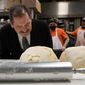 Chicago mayoral candidate Rep., Jesus &quot;Chuy&quot; Garcia, D-Ill., bends over to smell the fresh bread dough during a campaign stop at the Morelia Supermarket bakery Wednesday, Feb. 22, 2023, in Chicago. Garcia, who continues to seek the mayor&#x27;s office, forced then-Mayor Rahm Emanuel to a runoff in 2015. (AP Photo/Charles Rex Arbogast)