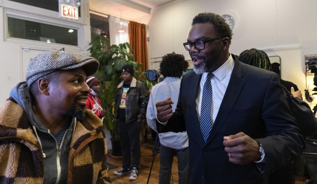 Chicago mayoral candidate Brandon Johnson, right, speaks with owner Bobby Price Chicago during a public listening session at Principle Barbers, Monday, Dec. 19, 2022, in the North Lawndale neighborhood of Chicago. Johnson is endorsed by the Chicago Teachers Union, a group that has tangled with Chicago mayor Lori Lightfoot, including during an 11-day teachers strike during her first year in office. (AP Photo/Erin Hooley, File)