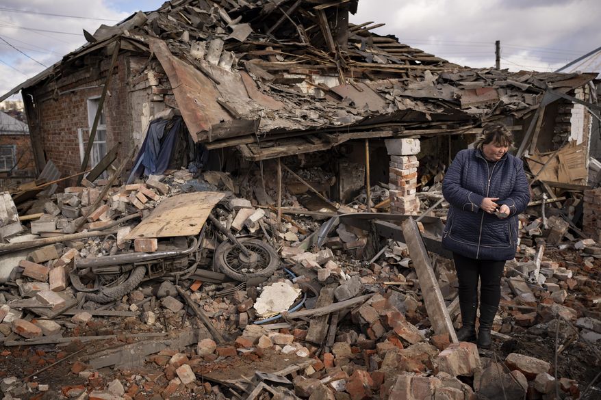 A woman holds a piece of shrapnel standing in the rubble of a house where Ukrainian servicemen were sheltering, which was destroyed by a Russian S-300 rocket strike, in Kupiansk, Ukraine, Monday, Feb. 20, 2023. Grueling artillery battles have stepped up in recent weeks in the vicinity of Kupiansk, a strategic town on the eastern edge of Kharkiv province by the banks of the Oskil River as Russian attacks intensifying in a push to capture the entire industrial heartland known as the Donbas, which includes the Donetsk and the Luhansk provinces. (AP Photo/Vadim Ghirda, File)