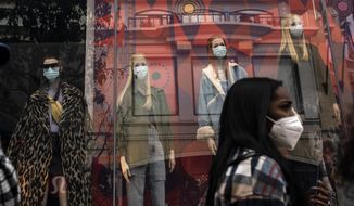 A shopper walks past mannequins donning face masks in Los Angeles, on Dec. 7, 2020. California&#x27;s COVID-19 emergency declaration ends on Tuesday, Feb. 28, 2023. Public health experts say the pandemic has not ended, but the virus is much more manageable with the availability of vaccines and other treatments. (AP Photo/Jae C. Hong) **FILE**