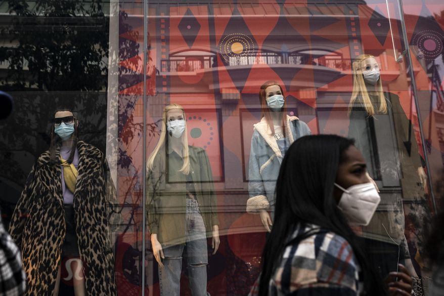 A shopper walks past mannequins donning face masks in Los Angeles, on Dec. 7, 2020. California&#x27;s COVID-19 emergency declaration ends on Tuesday, Feb. 28, 2023. Public health experts say the pandemic has not ended, but the virus is much more manageable with the availability of vaccines and other treatments. (AP Photo/Jae C. Hong) **FILE**