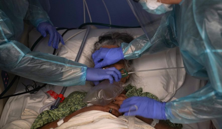 Two nurses put a ventilator on a patient in a COVID-19 unit at St. Joseph Hospital in Orange, Calif. Thursday, Jan. 7, 2021. California&#x27;s COVID-19 emergency declaration ends on Tuesday, Feb. 28, 2023. Gov. Gavin Newsom first issued the emergency declaration on March 4, 2020. The emergency ends just as California officially passed 100,000 COVID-related deaths during the pandemic. (AP Photo/Jae C. Hong, File)