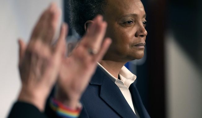 Chicago Mayor Lori Lightfoot pauses during her concession speech as her spouse Amy Eshleman applauds during an election night party for the mayoral election Tuesday, Feb. 28, 2023, in Chicago. (AP Photo/Charles Rex Arbogast)