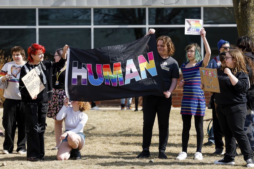 Bettendorf High School students gather outside the main entrance to the school as they walk out in support of Iowa's LGBTQ+ students and youth in response to pending legislation, Wednesday, March 1, 2023, in Bettendorf, Iowa. Bettendorf students joined dozens of other Iowa High Schools participating in the "We Say Gay" walkout organized by the Iowa Queer Student Alliance in response to proposed legislation in the Iowa statehouse. (Nikos Frazier/Quad City Times via AP)