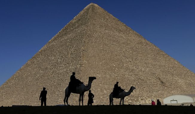 Policemen are silhouetted against the Great Pyramid in Giza, Egypt, Dec 12, 2012. Egypt unveiled on Thursday, March 2, 2023, the discovery of a 9-meter-long chamber inside the Great Pyramid of Giza, the first to be found on the structure’s north side. (AP Photo/Hassan Ammar, File)