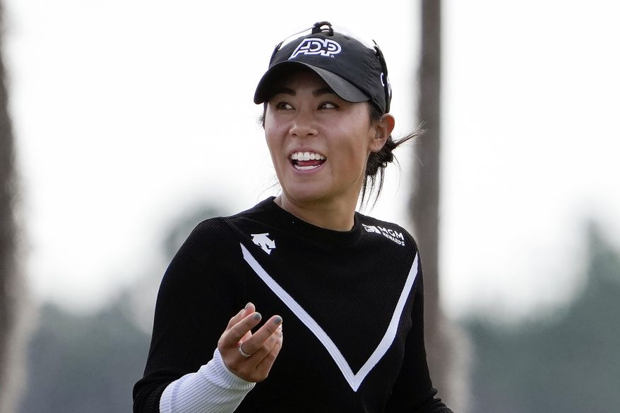 Danielle Kang shares a laugh with her caddie as she walks to the 18th green during the first round of the LPGA Hilton Grand Vacations Tournament of Champions, Jan. 19, 2023, in Orlando, Fla. Kang avoided distractions in a rain-soaked round and shot a 9-under 63 on Friday, March 3, 2023 for a one-shot lead after the second round of the Women&#x27;s World Championship in Singapore. (AP Photo/John Raoux, File)